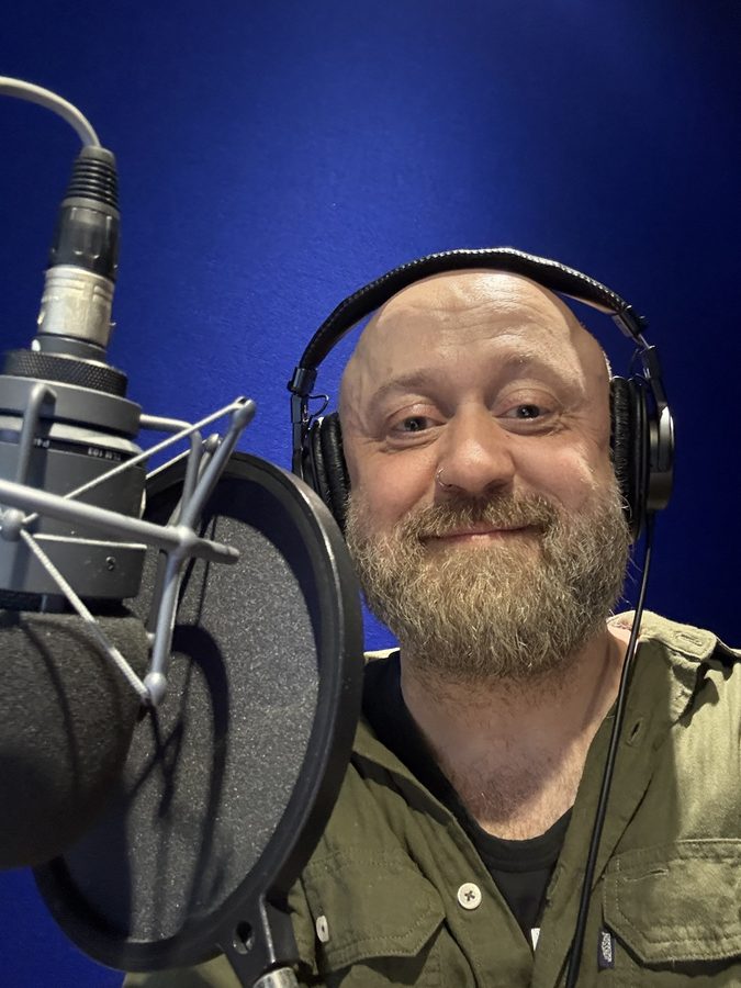 Damian Dudkiewicz at the microphone in a recording studio